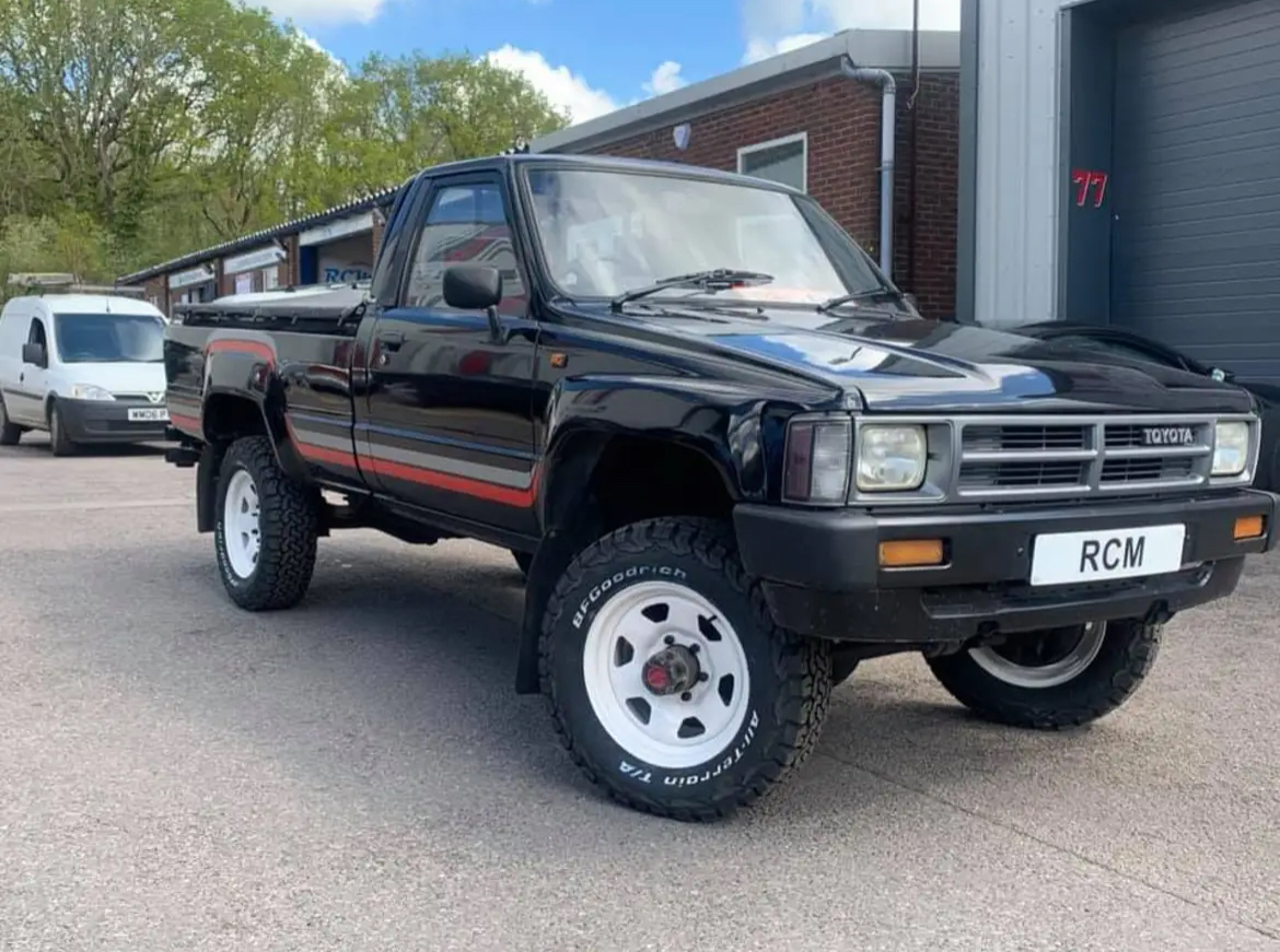 A Toyota pickup with an RCM number plate parked outside the workshop